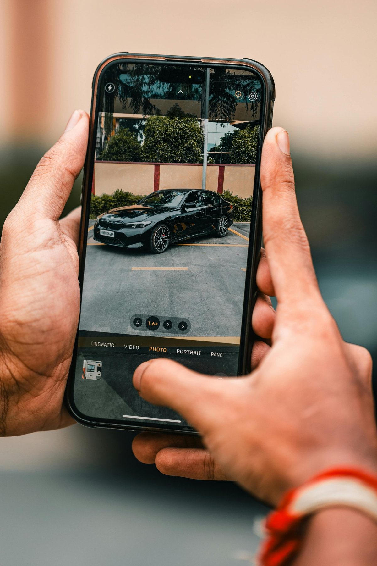 Ein Fahrzeug wird mit einem Smartphone fotografiert