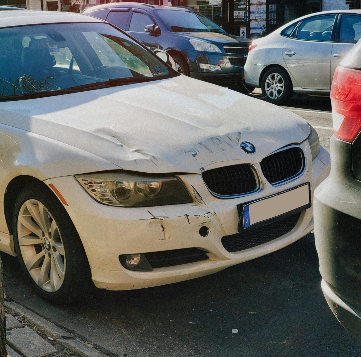 Weißer Pkw mit beschädigter Motorhaube und Stoßfänger